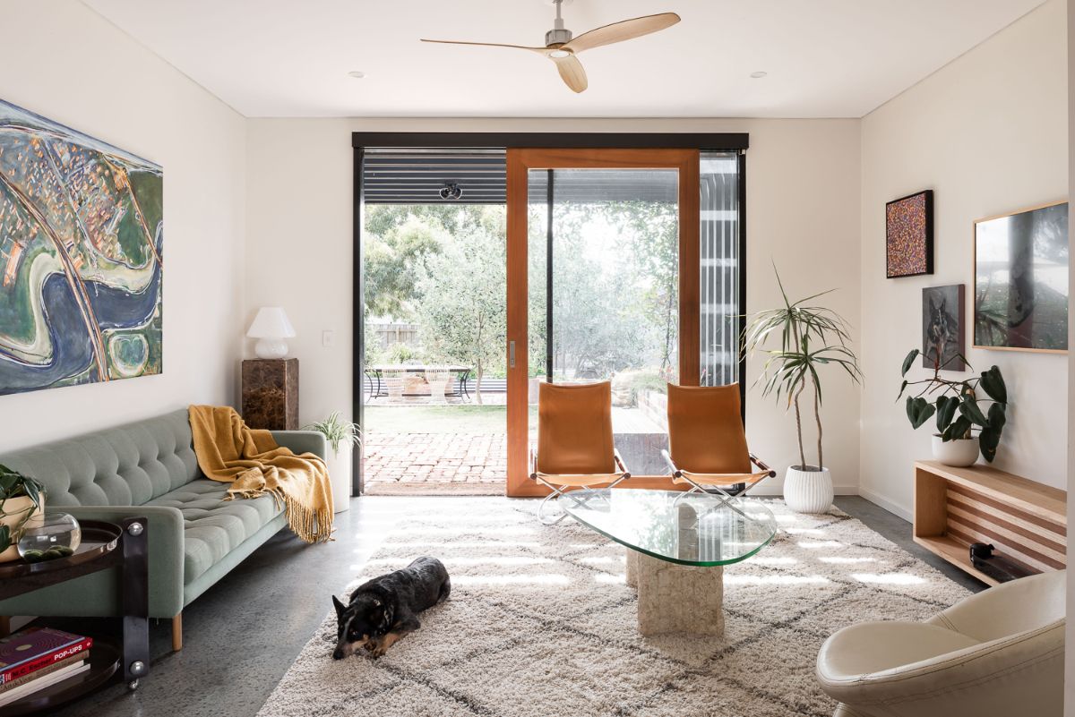 The living room with large glazed sliding doors that are shaded by painted LVL timber beams, filtering light through in a delicate way. 