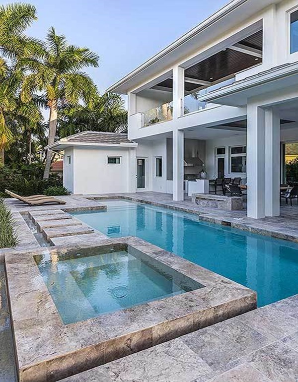 The swimming pool with an integrated spa has limestone paving and a fire pit.