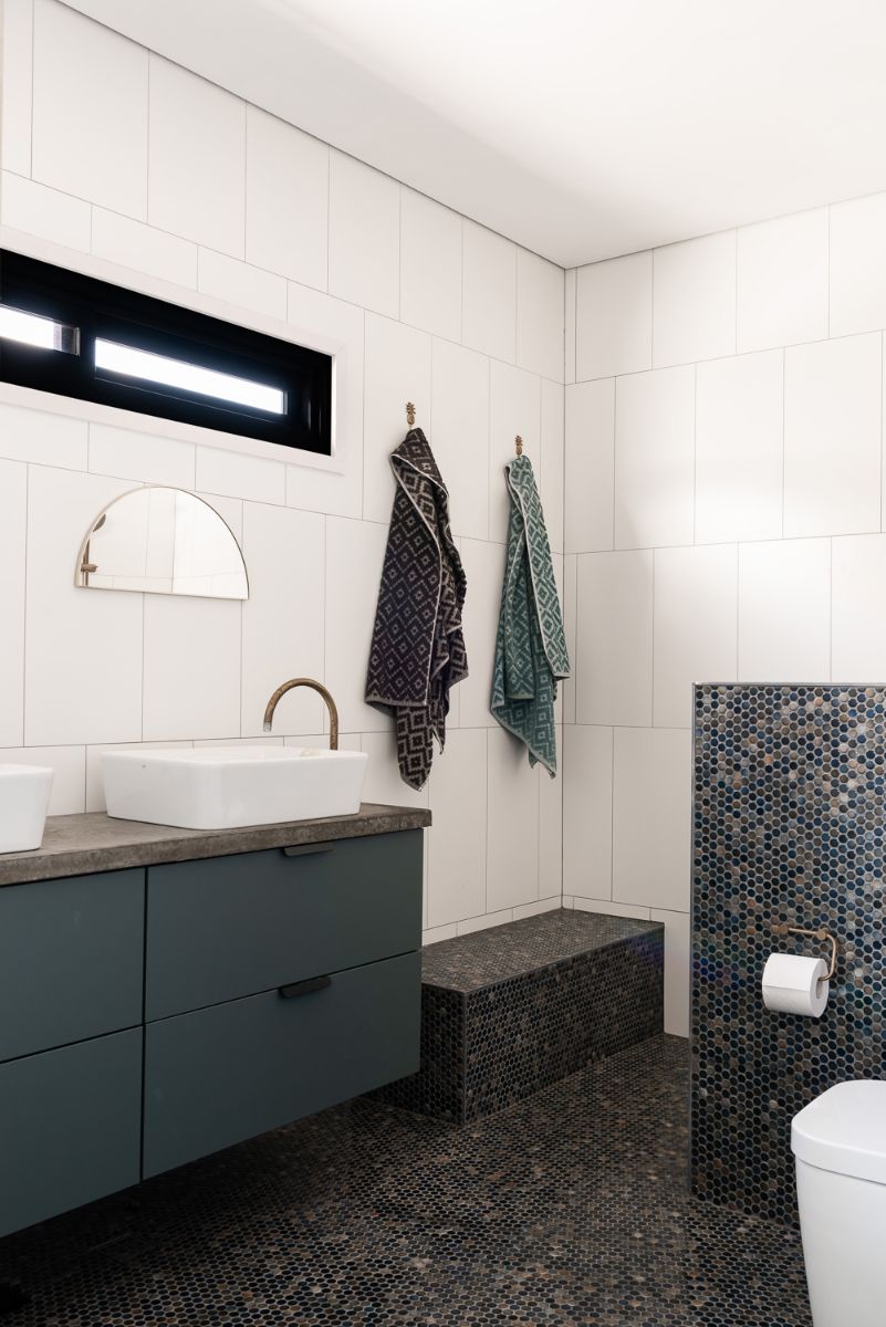 A bathroom with patterned tile flooring, white walls, and a counter-topped sink positioned on a floating cabinet.