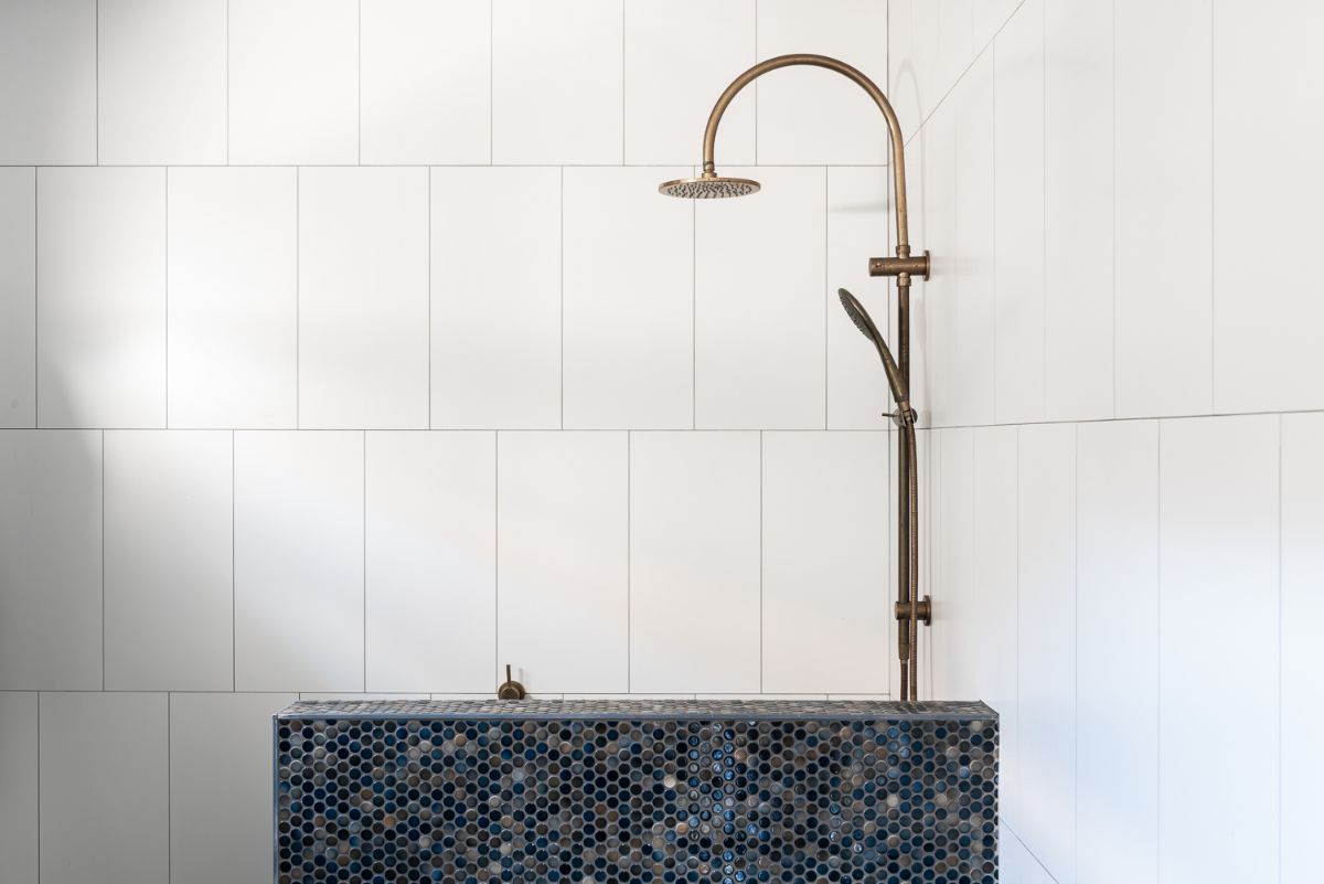 There is also a shower area with wrought iron fixtures in the bathroom.