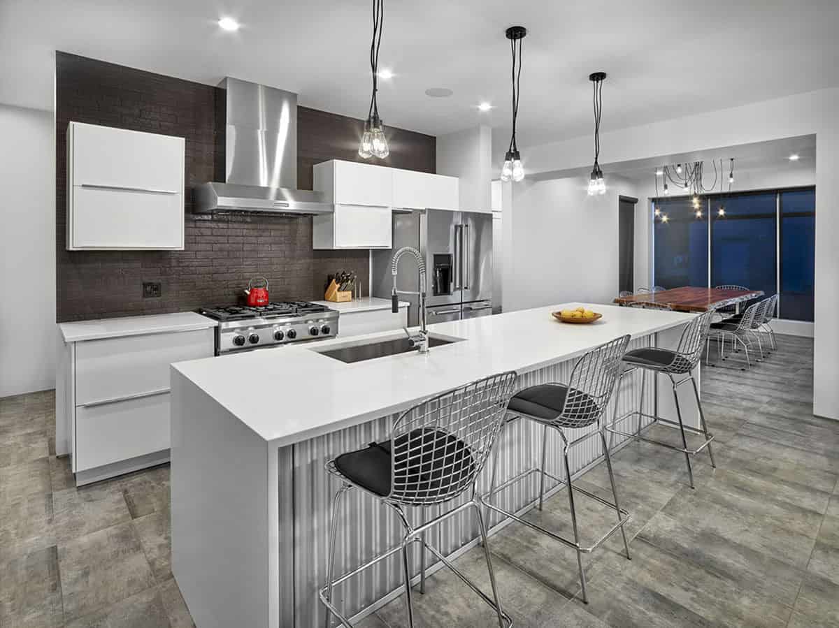 The tiled flooring continues to the kitchen brightened by wrought iron pendants and recessed ceiling lights.