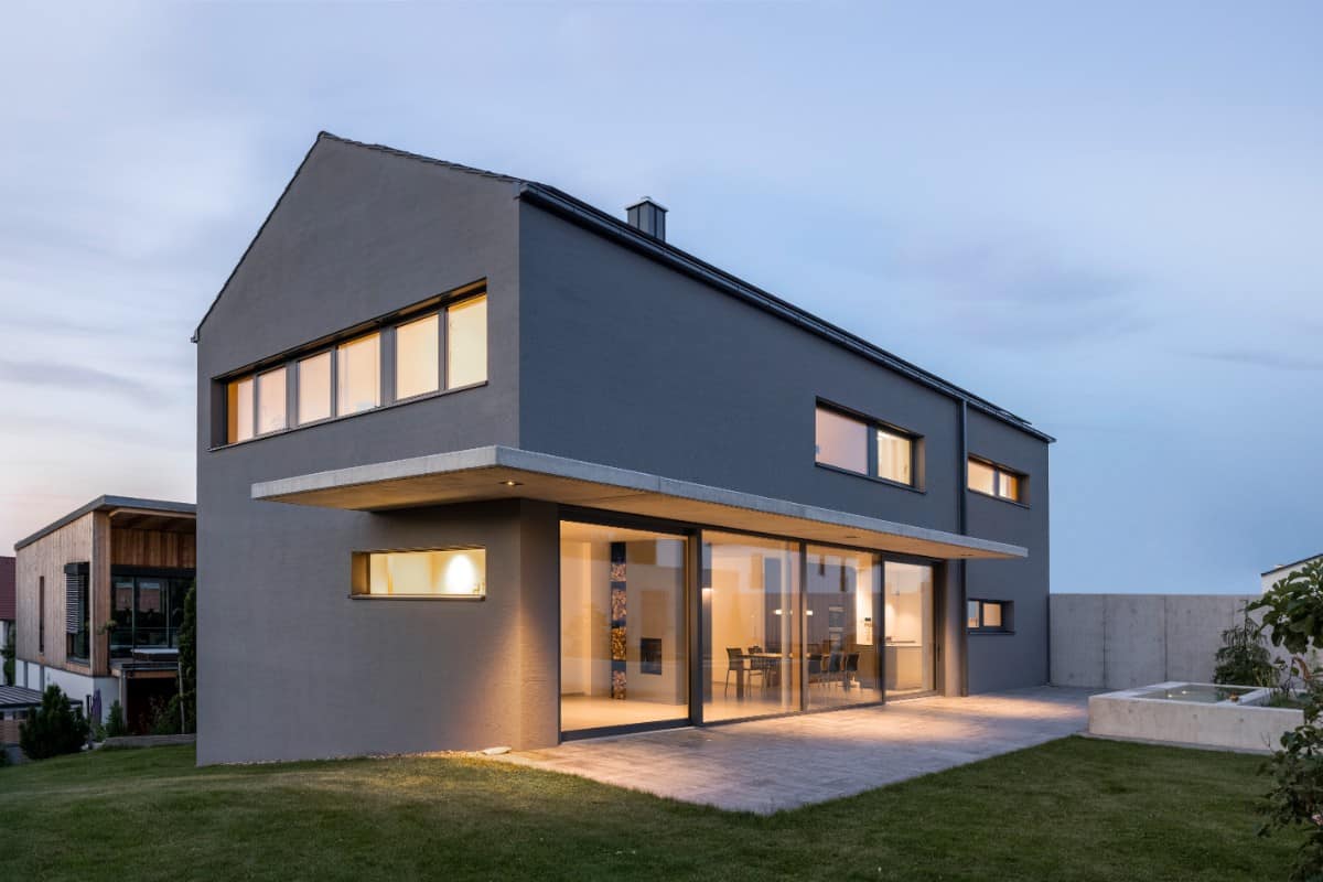 Home's rear facade showcasing a concrete patio with sliding glass doors.