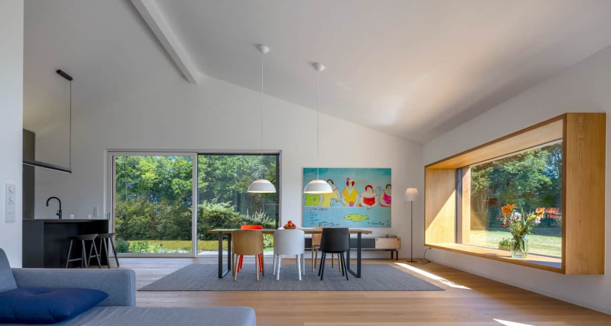 An open layout view of the living room, dining area, and kitchen under a vaulted ceiling.