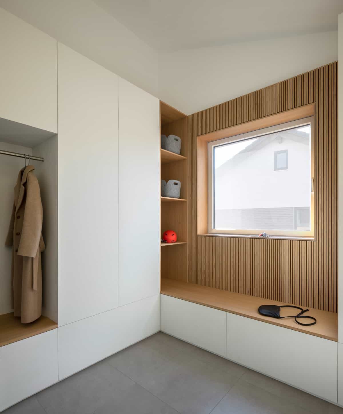 The walk-in closet offers plenty of storage space and a built-in seat under the sleek window.