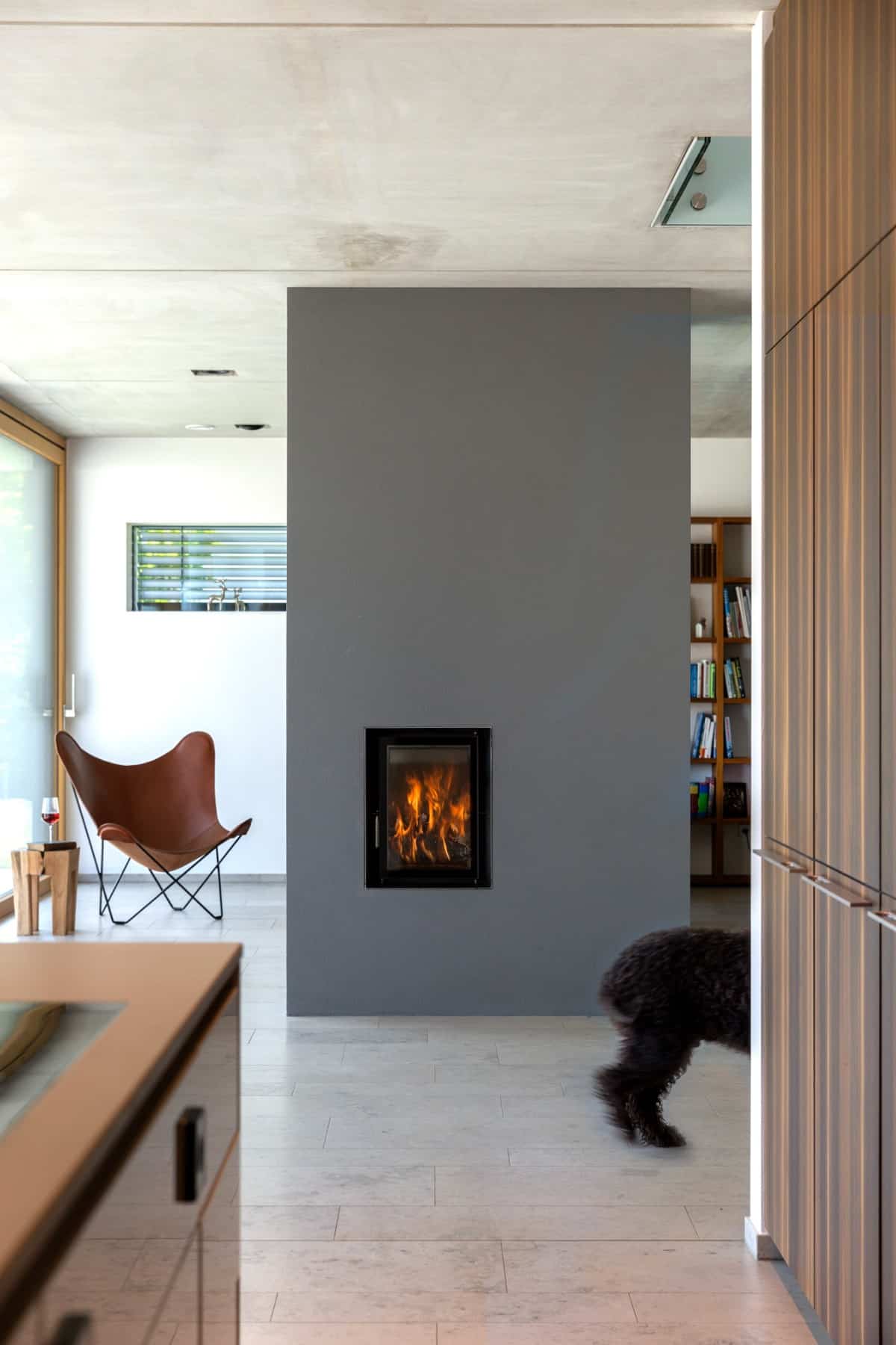 A large pillar fitted with a double-sided fireplace separates the eat-in kitchen and living room.