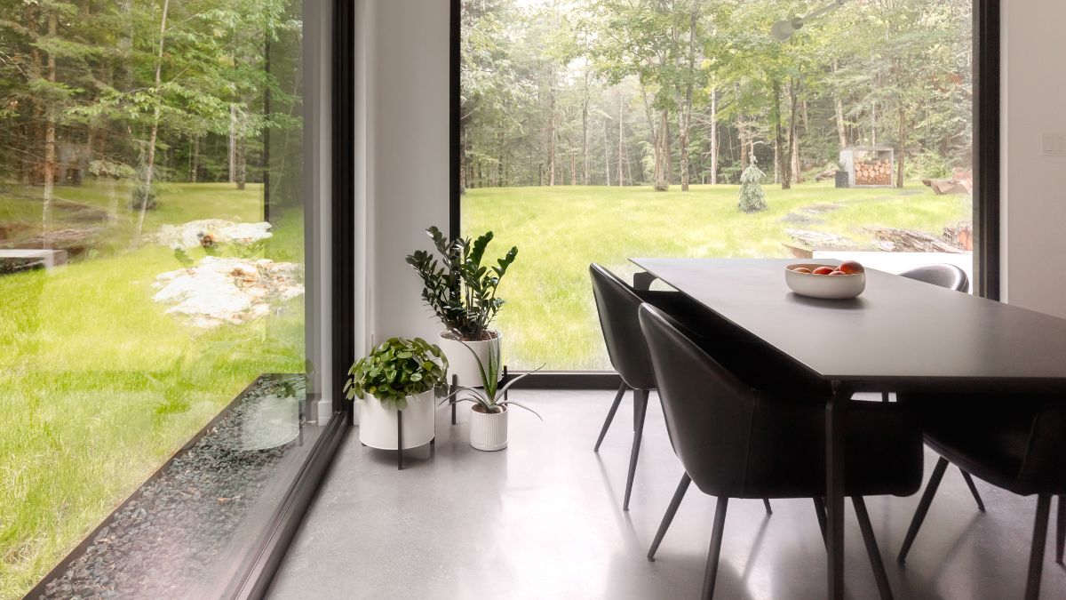 The eating area includes enormous box-shaped glass windows that provide a magnificent view of the outside.