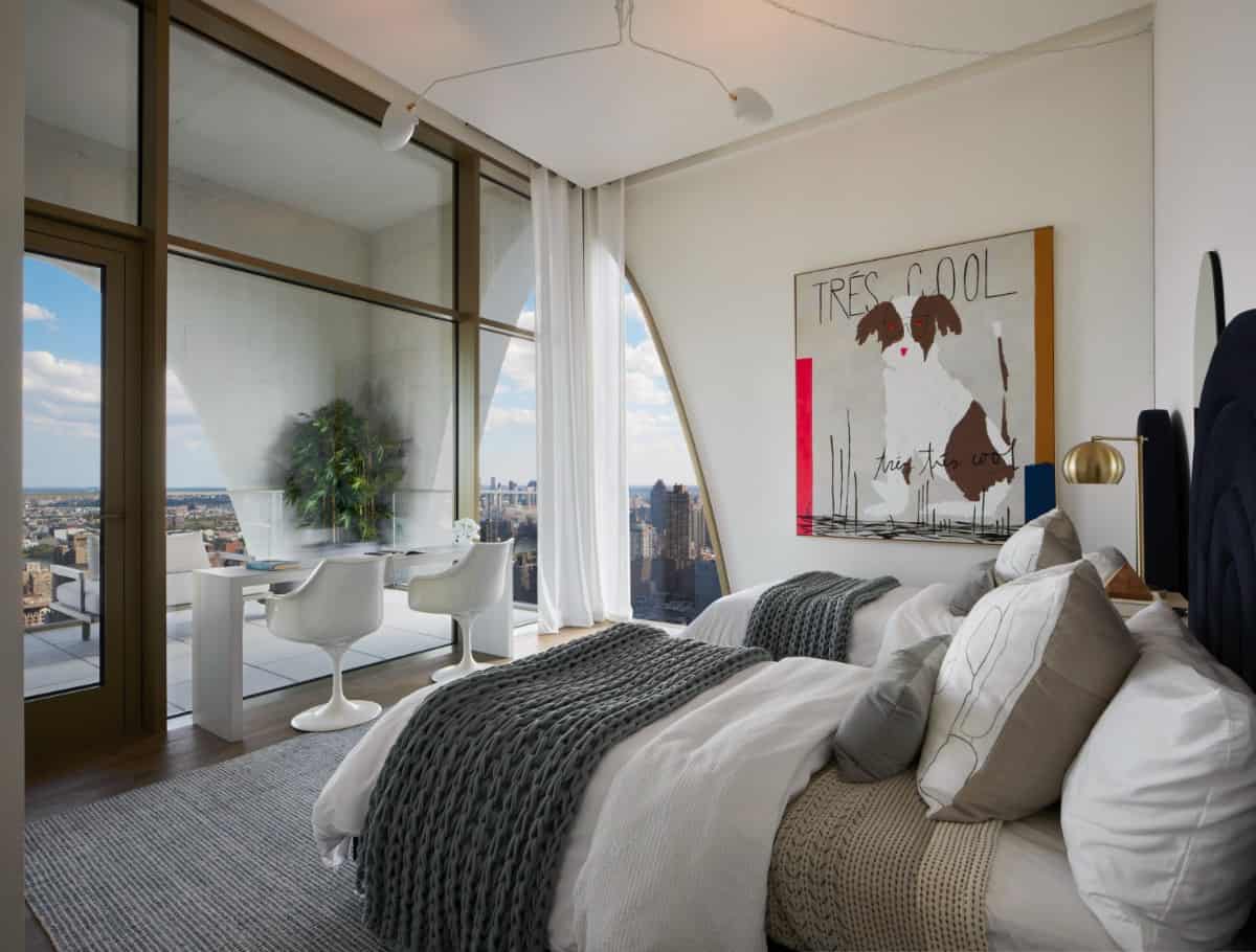 Another bedroom with a private terrace. It includes two beds and a long desk paired with a couple of white modern chairs.