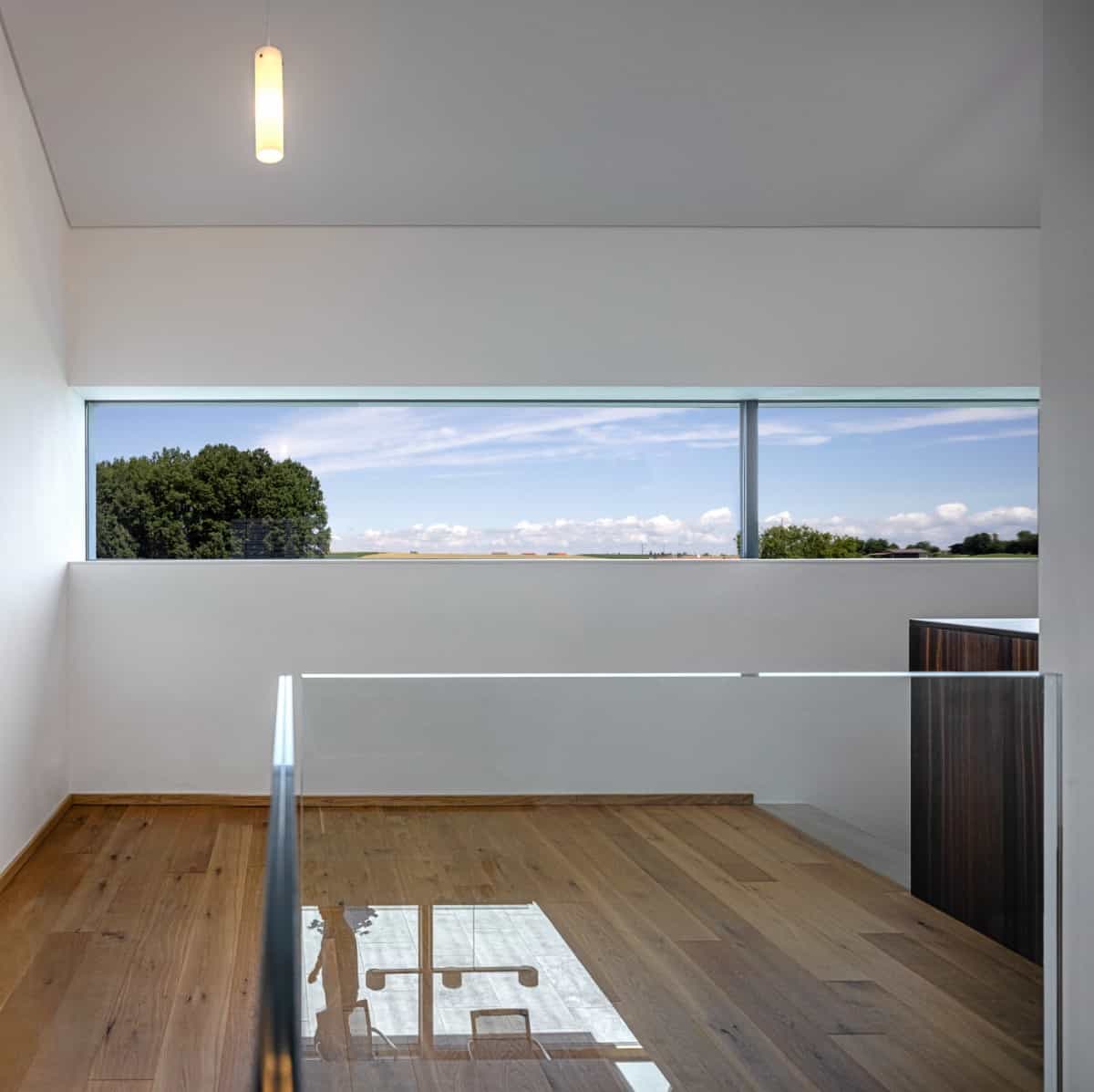 Panoramic windows brighten the second-level loft as it takes in spectacular views of the surrounding landscape.