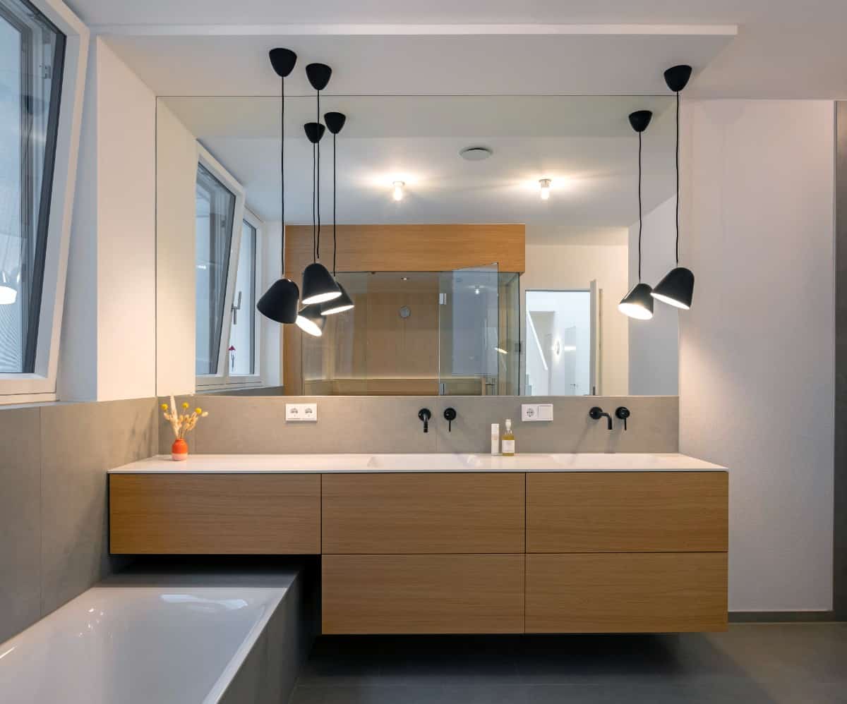 Wrought iron pendants illuminate the floating vanity.