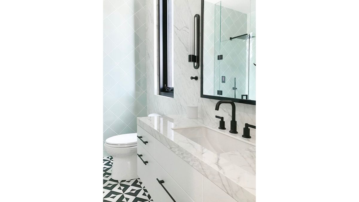 This one includes a rectangle mirror, a marble sink, and black and white tile flooring.