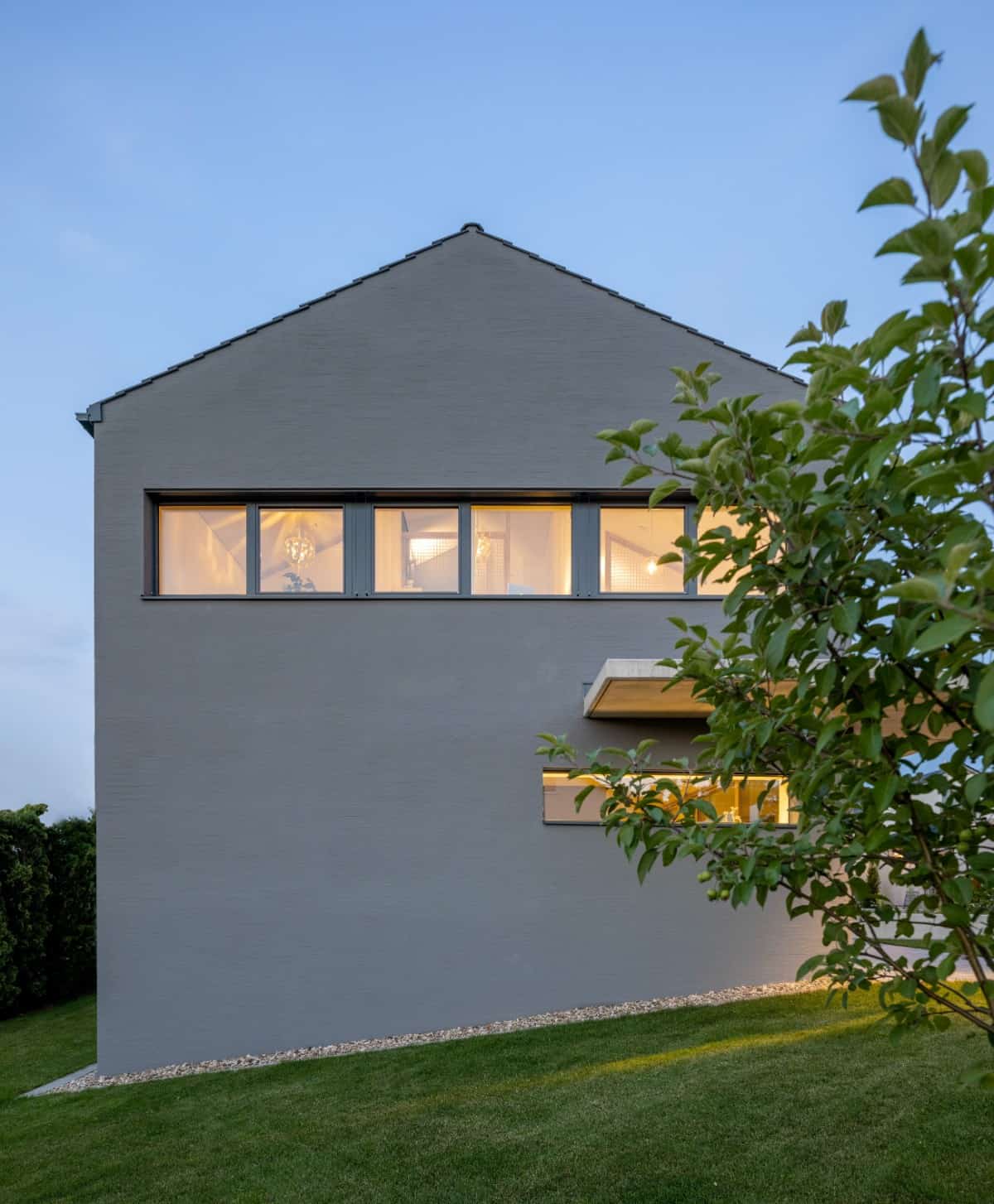 Side view of the house showcasing its panoramic windows and sloped exterior.