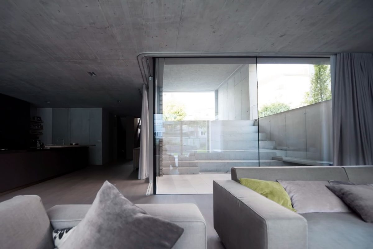 A view of the underground floor's living room, with glass-enclosed concrete steps leading to the ground floor.