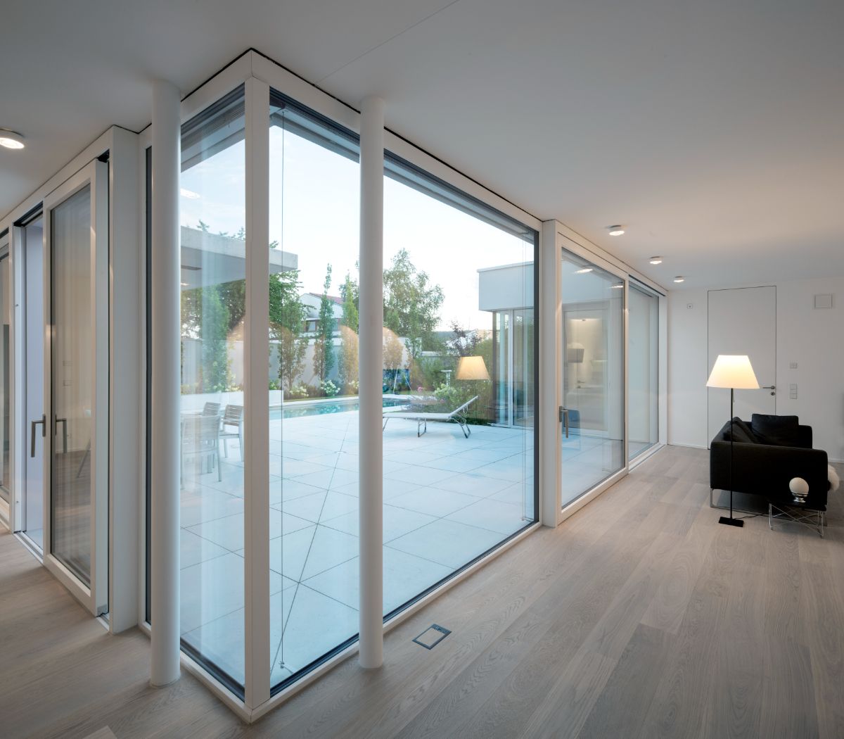 Through the glass wall of the enclosed atrium, which opens on the corner to the pool and garden, the four separate cubes of the house can share a view.