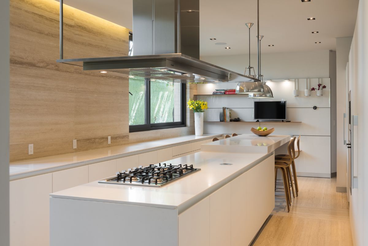 A neutral palette of light tones was employed in the kitchen. A clean-lined white island and light wood on the floor all the way to the wall add a modern touch.