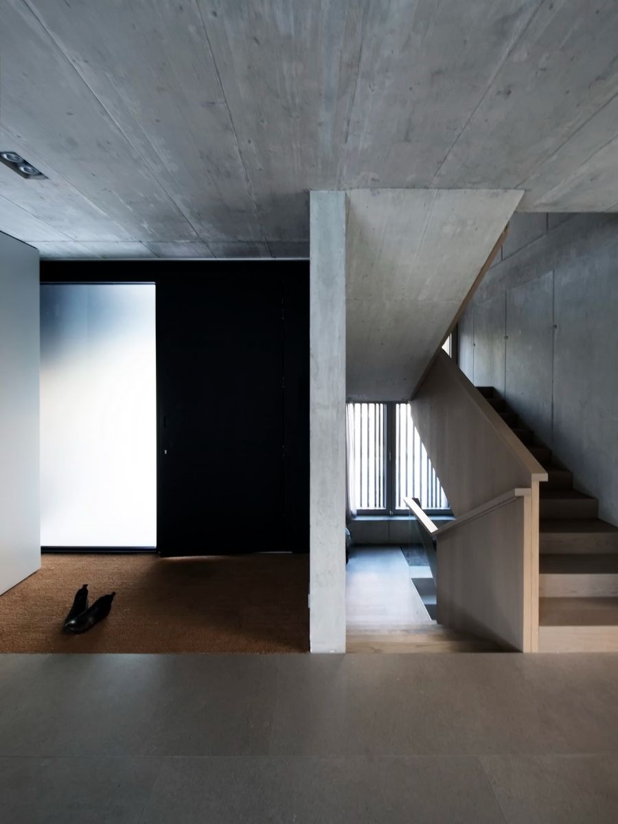 Concrete features dominate the house's interior design, as evidenced in the floor, walls, and staircase.