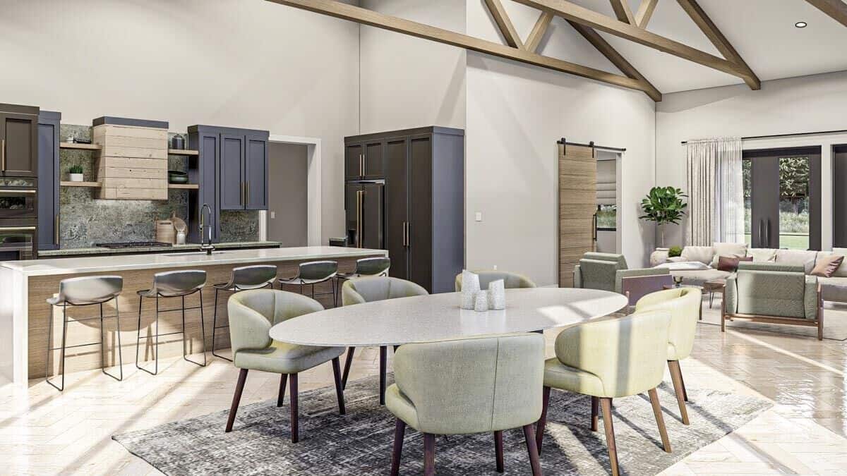 An open layout view of the kitchen, dining area, and great room under a vaulted ceiling.