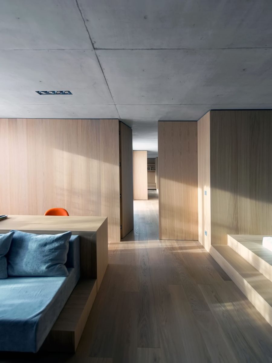 The wooden structures in the bedroom include the floors, wall, and bed. The ceiling is constructed of concrete. 