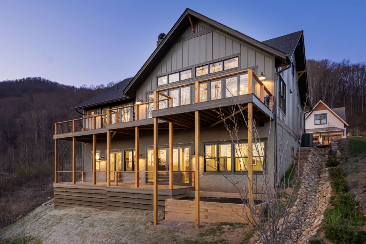 A mountain hill house with exceptional architectural and design characteristics such as expansive windows, fully retractable sliding doors, and a deck.