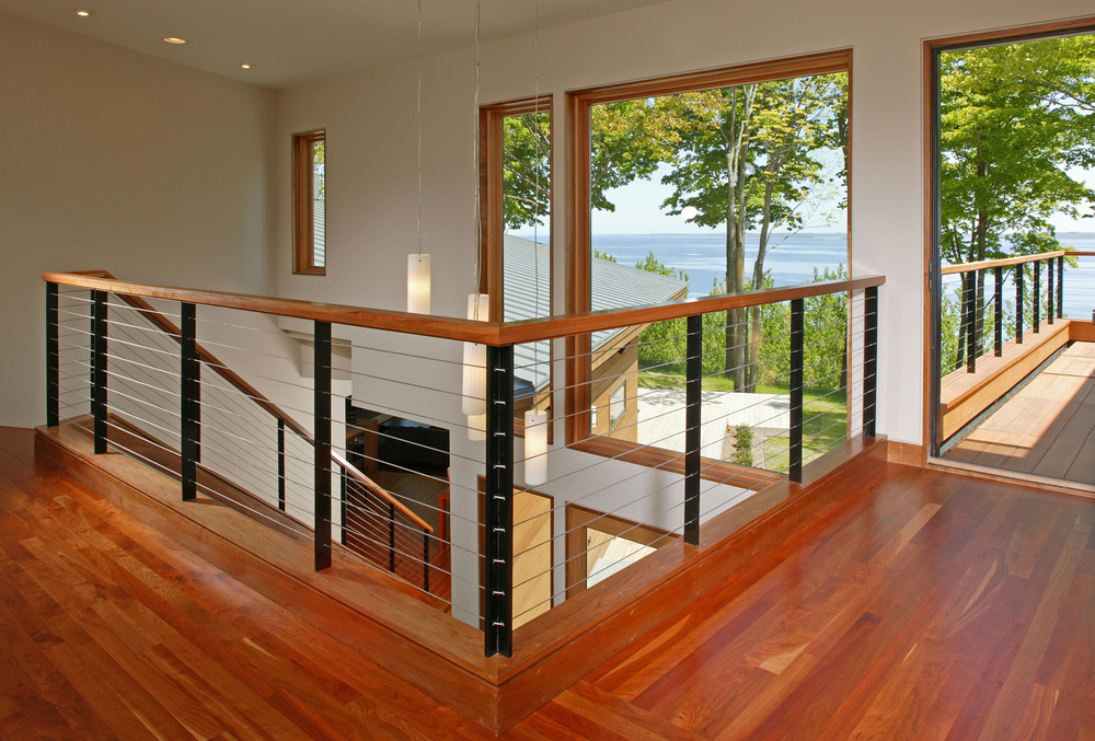 A pathway from the stairs leads to the terrace, which has cherry flooring and a mix of metal and wood railings. With large windows to enjoy the scenery outside.