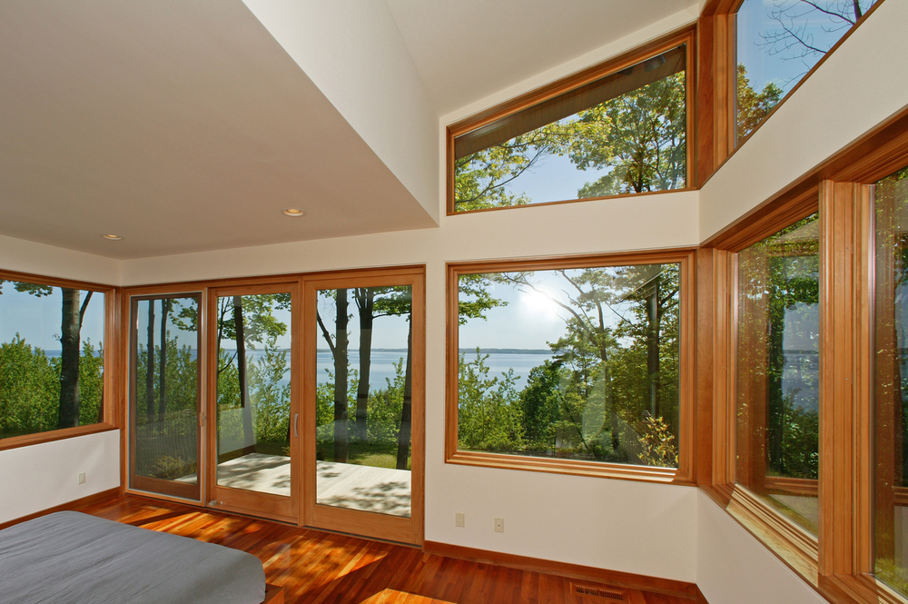 A light-filled bedroom with big windows that make the space feel larger and provide uninterrupted views of the lake.