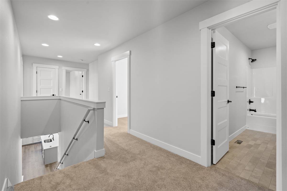 Hallway with carpeted floor leading to the secondary bedrooms.