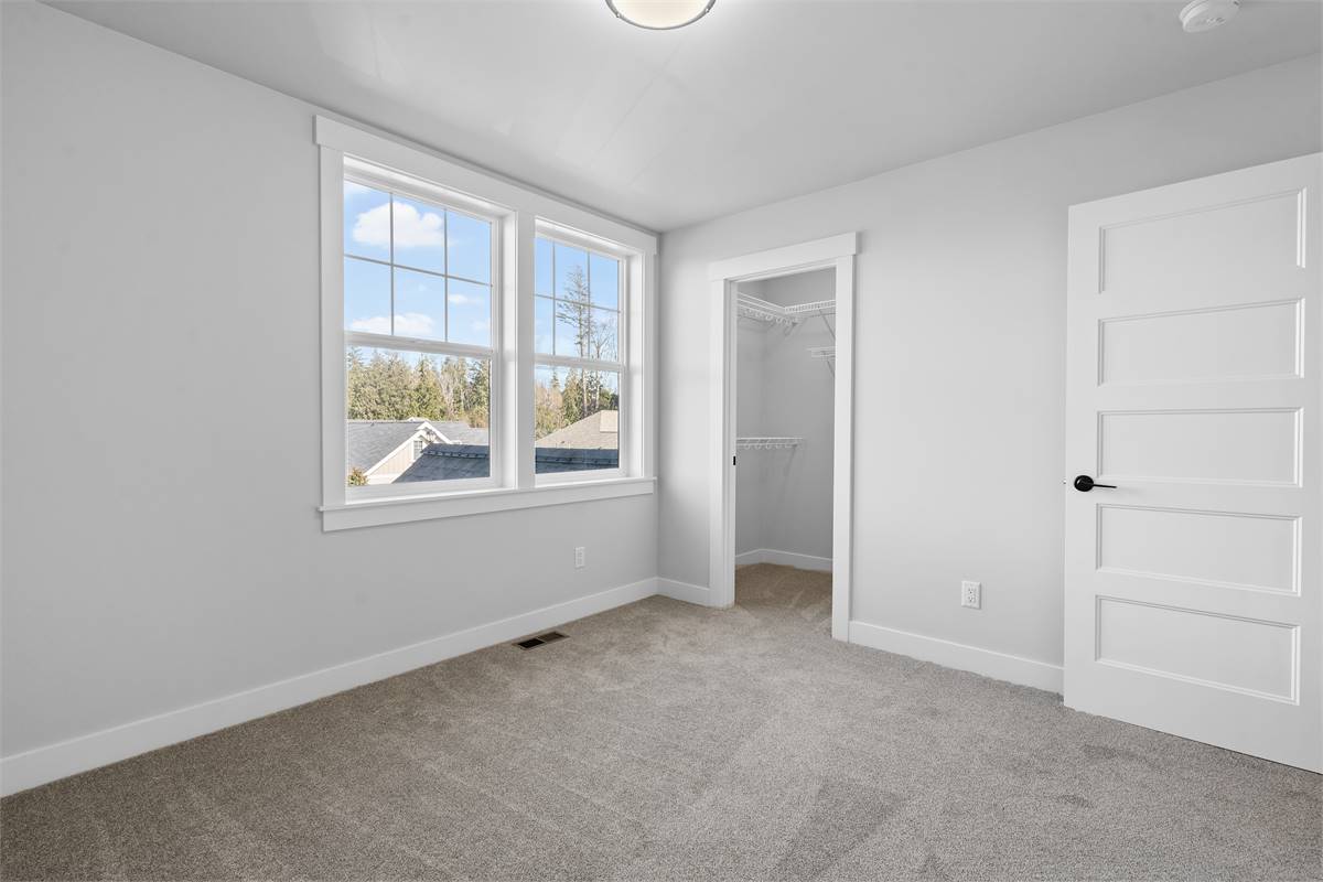 This bedroom has carpet flooring and a walk-in closet.