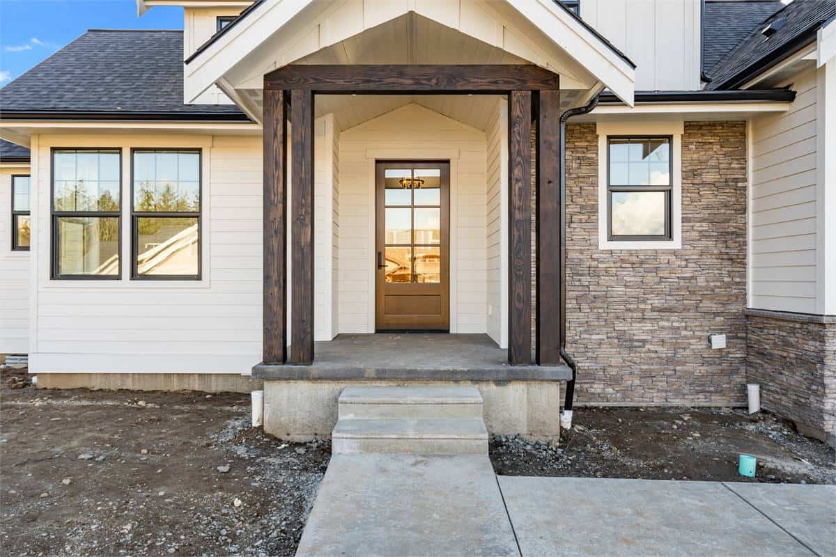 Rustic timber beams frame the covered entry porch.