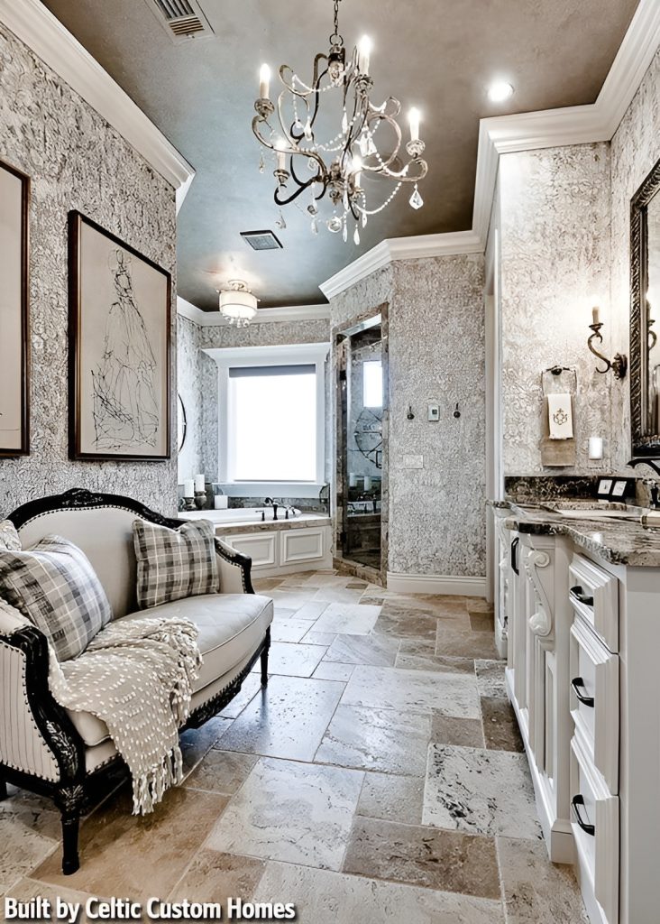 Primary bathroom with a whirlpool corner tub, walk-in closet, and a sink vanity facing the cushioned sofa that's illuminated by a beaded chandelier.