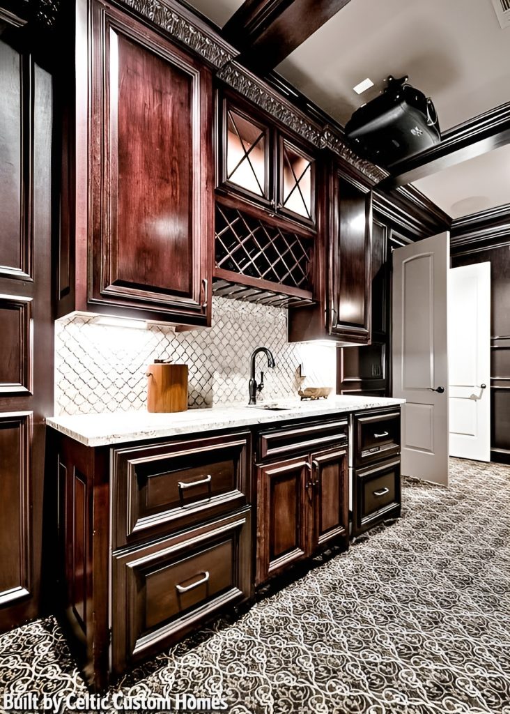 A closer look at the wet bar with a white marble countertop, undermount sink, dark wood cabinets, and wine shelves.