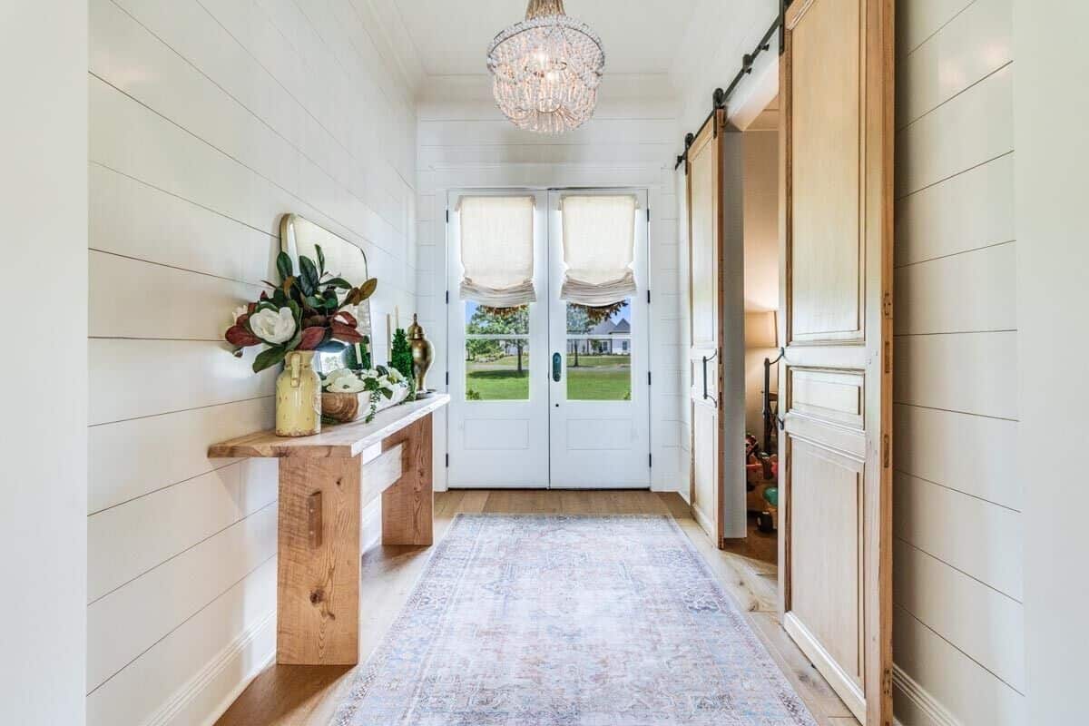 Foyer with a French entry door and a rustic console table against the shiplap wall.