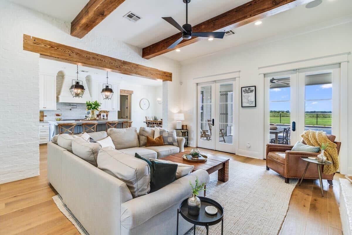 A large opening highlighted by a timber beam connects the living room and eat-in kitchen.