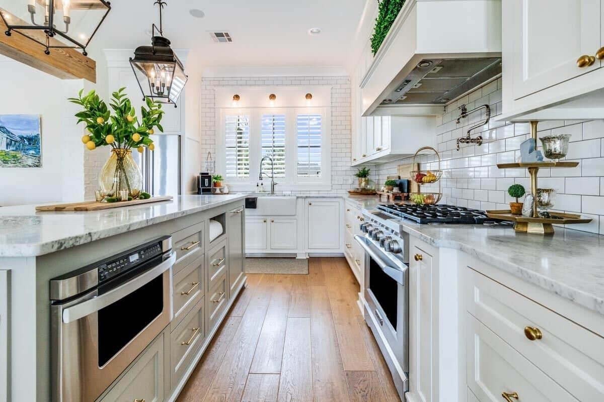 The kitchen includes top-notch appliances and a farmhouse sink situated underneath the louvered windows.