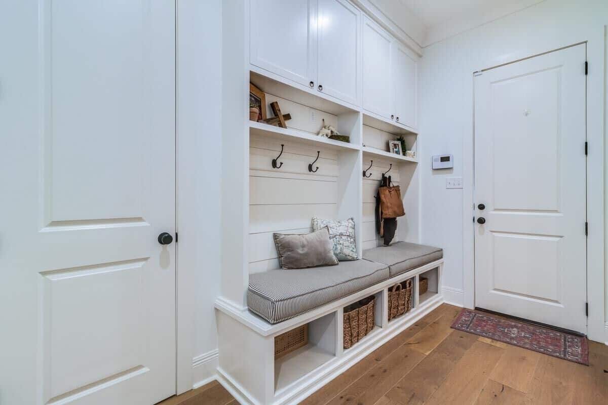 The mudroom offers extra storage, coat hooks, and a cushioned bench.