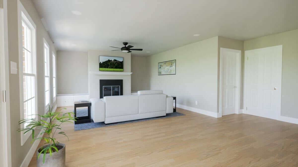 Upstairs living room with a white sofa and a TV mounted above the fireplace.