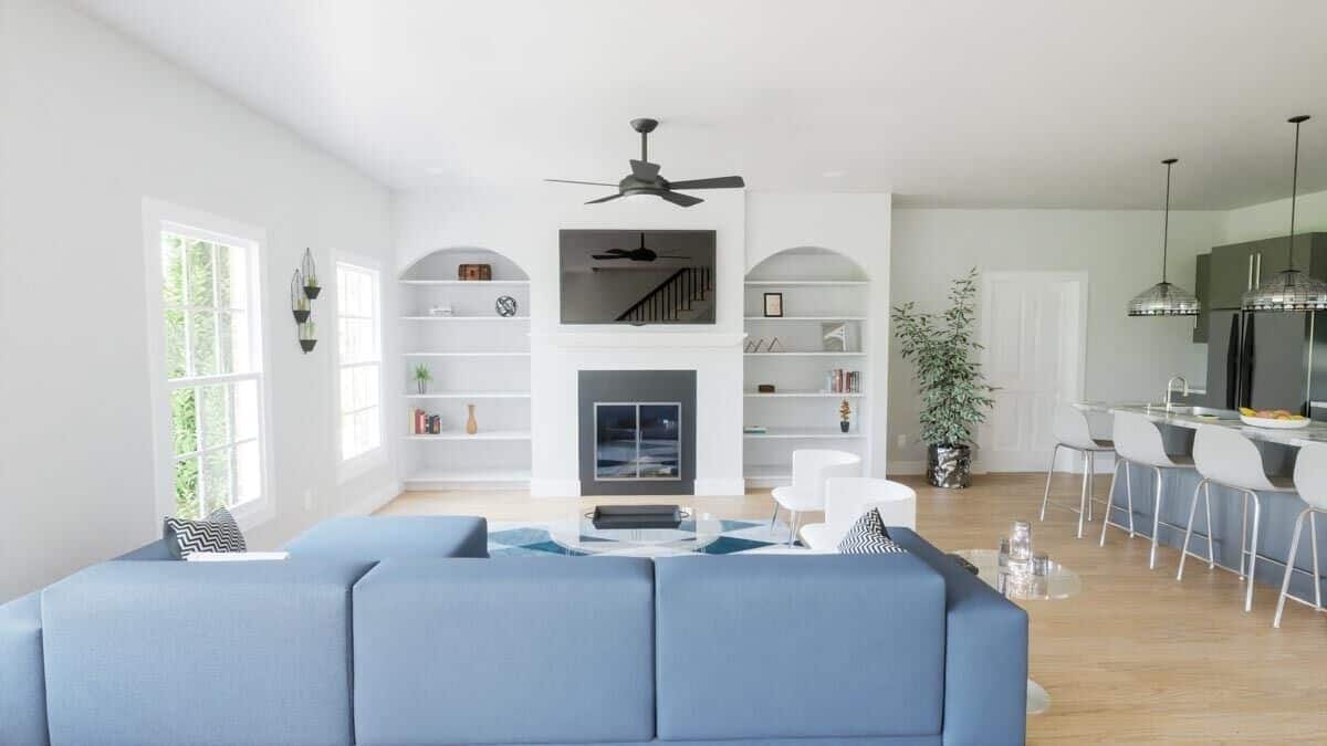 Family room with modern furnishings, a wall-mounted TV, and a fireplace flanked by built-in shelves.