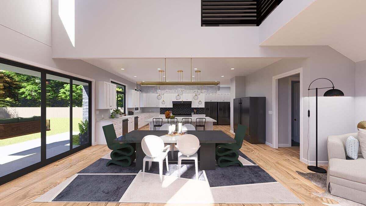 Dining area with a slate table surrounded by contemporary chairs over a large patterned rug.