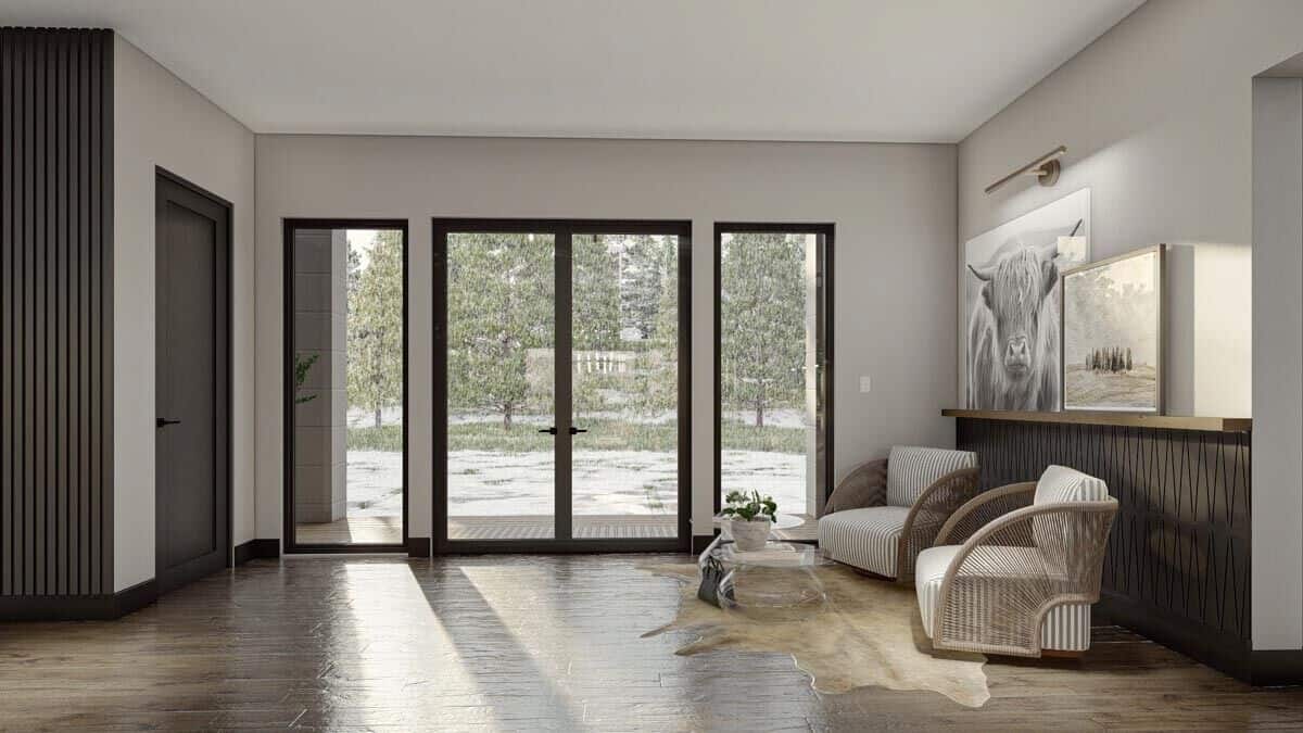 A French entry door welcomes guests into a spacious foyer with wicker armchairs.