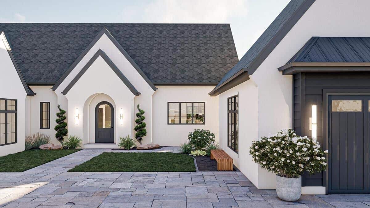 Front view of the house showcasing stacked gables and an arched entry with a glazed front door.