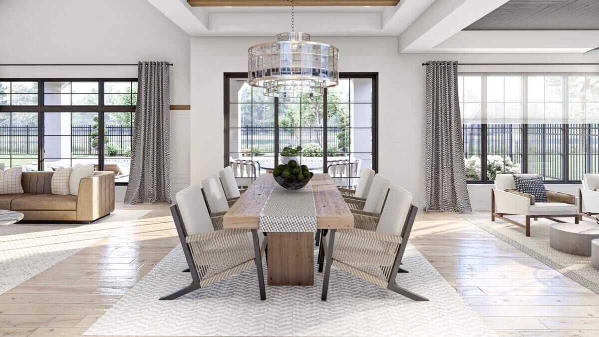 The dining room has a glass drum pendant and a wooden dining set sitting on a patterned area rug.