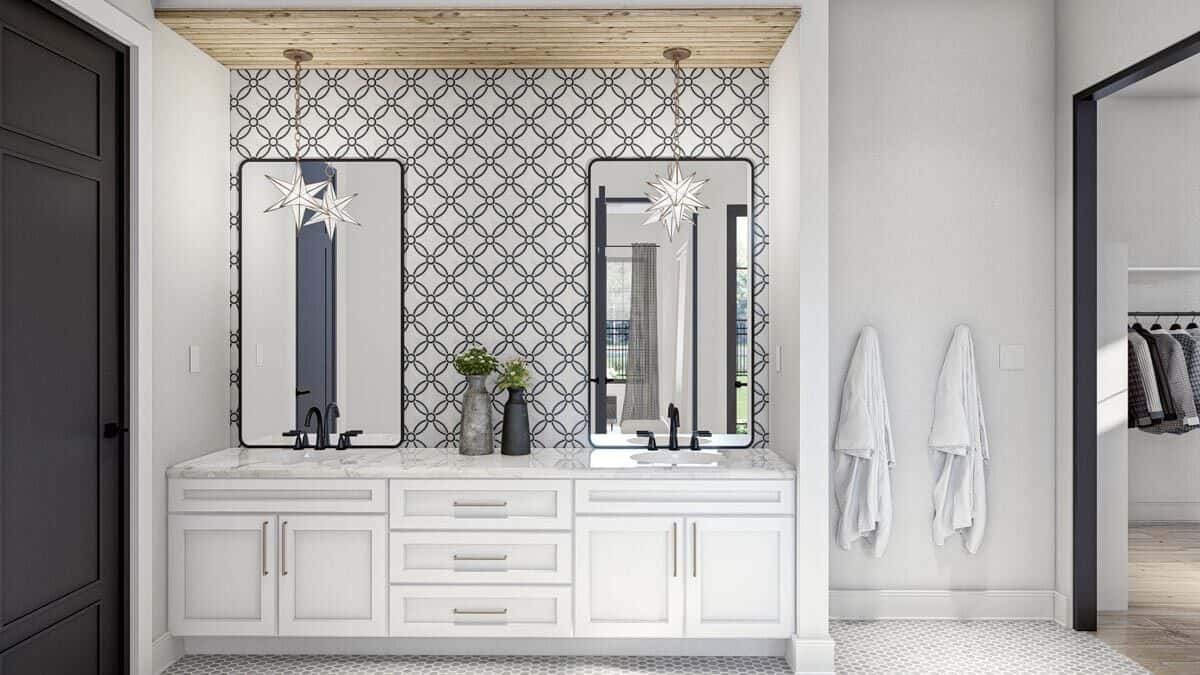 Primary vanity with white cabinets, double sinks, and rectangular mirrors highlighted by patterned wallpaper.