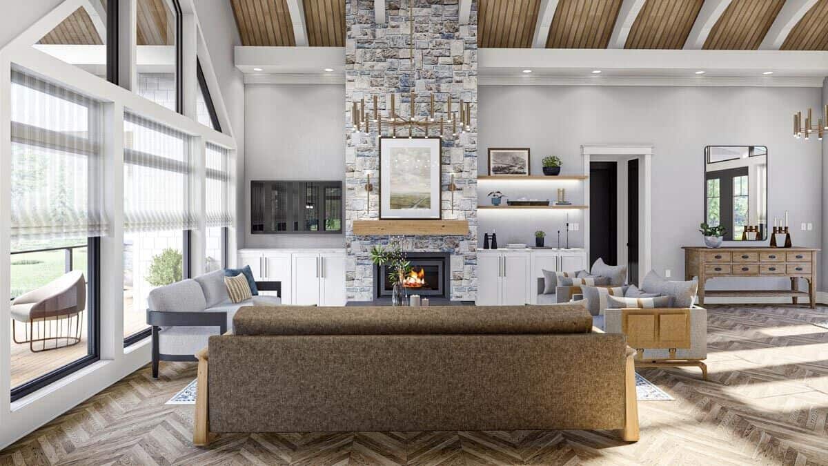 The great room includes a stone fireplace and a cathedral ceiling accentuated with exposed beams.