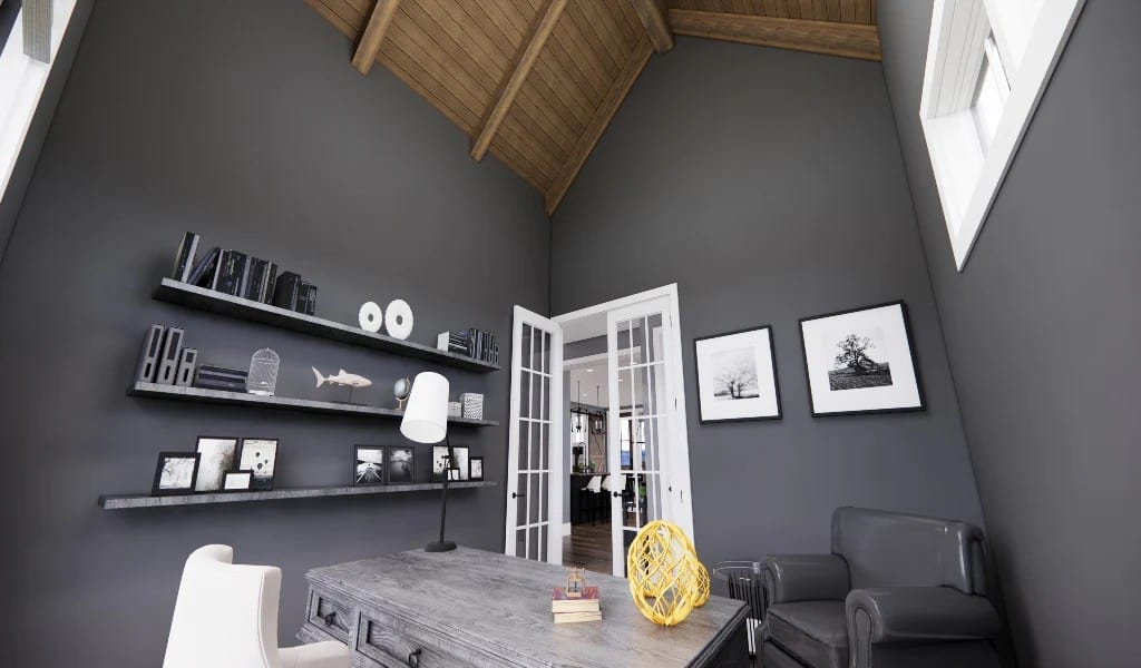 The home office has a vaulted ceiling, floating shelves, and a rustic desk complemented with leather chairs.