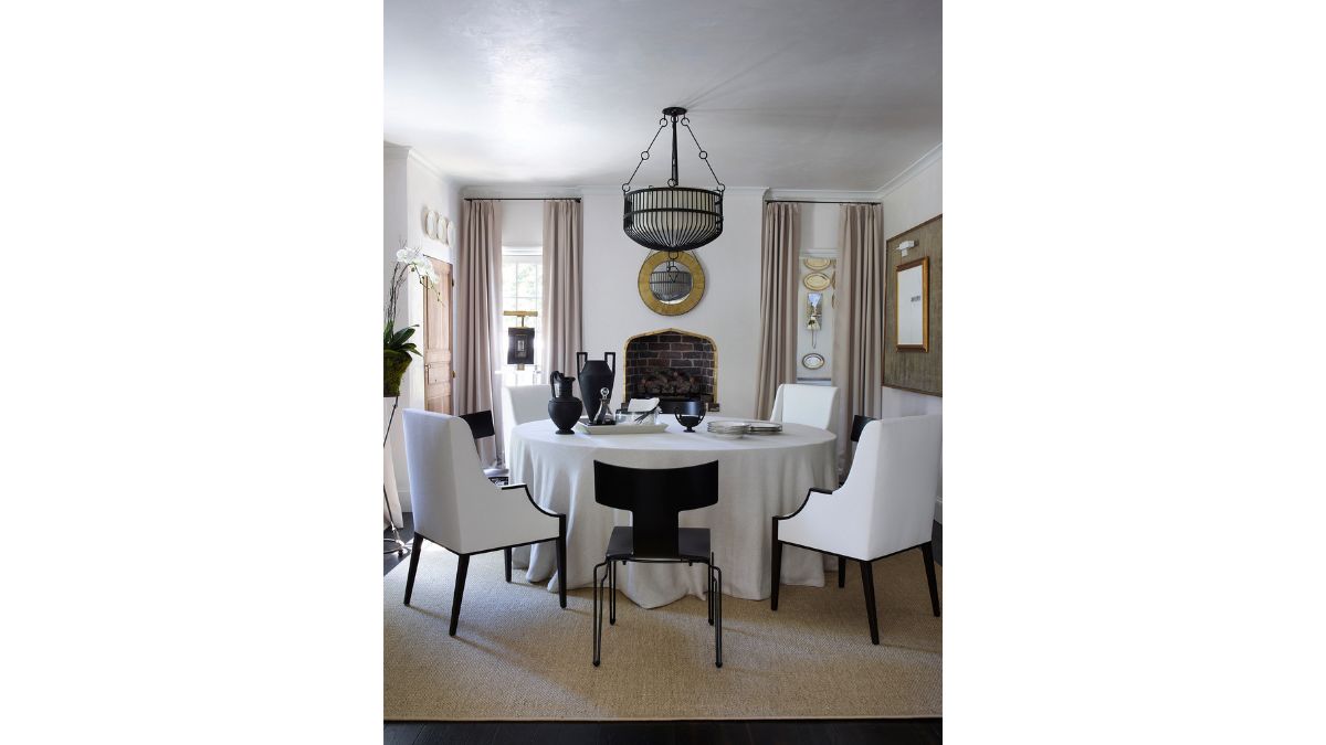 The formal dining area is situated beneath a hanging lamp.