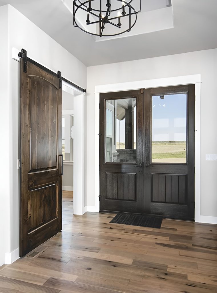 Foyer with a french front door, a wrought iron pendant, and a barn door that slides open to a quiet den.