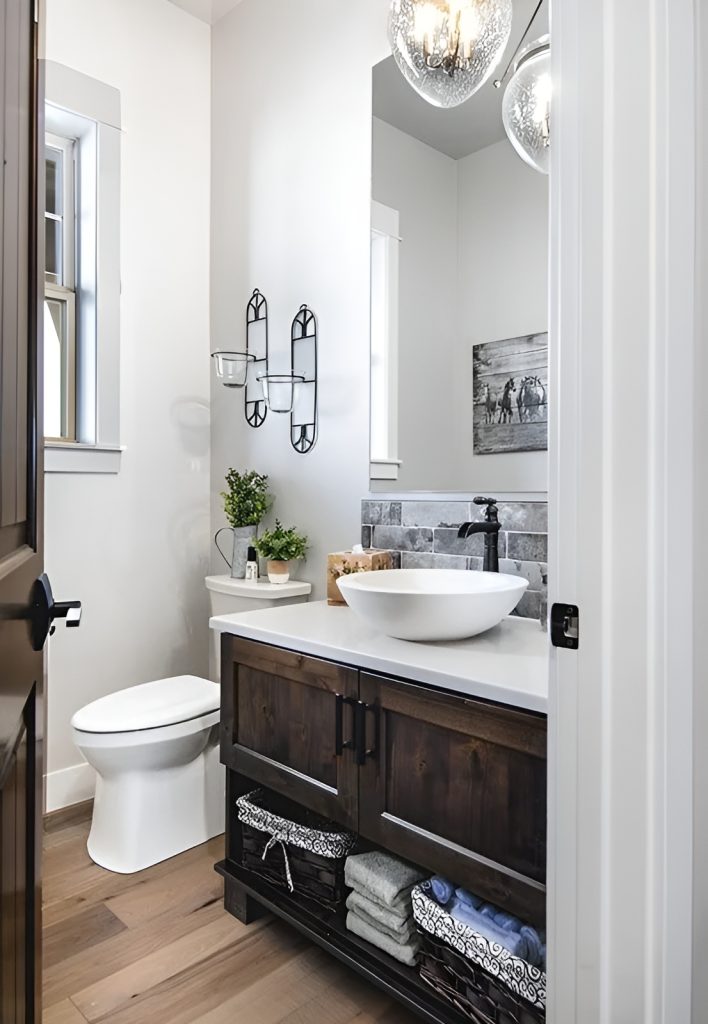 The powder room offers a toilet and a dark wood vanity with a vessel sink, an iron faucet, and a frameless mirror.