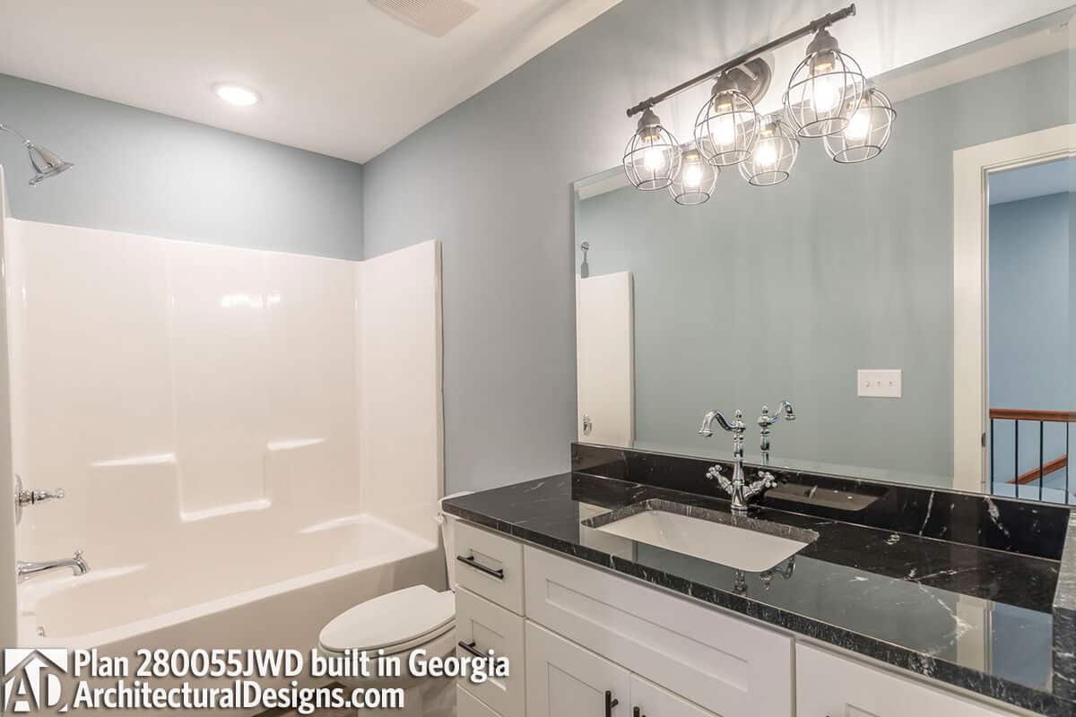 Bathroom with a marble-top vanity and a tub and shower combo.