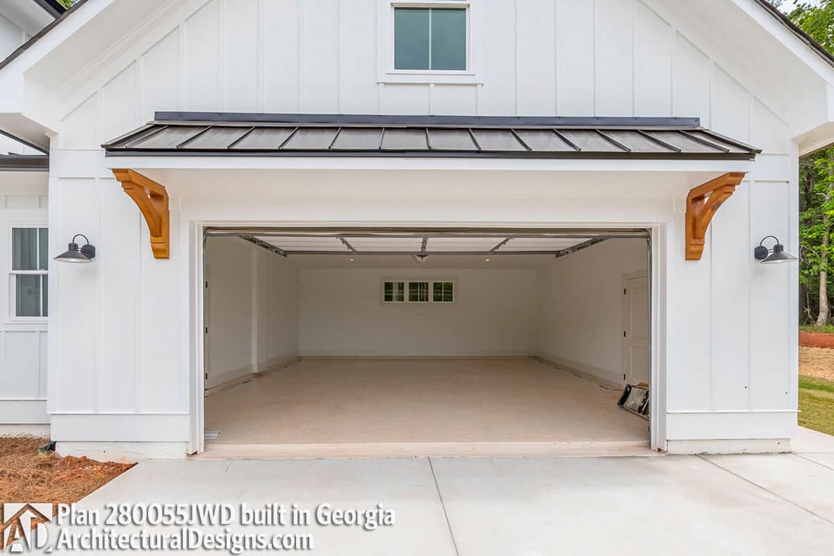 Garage with a metal awning and a parking space for two vehicles.