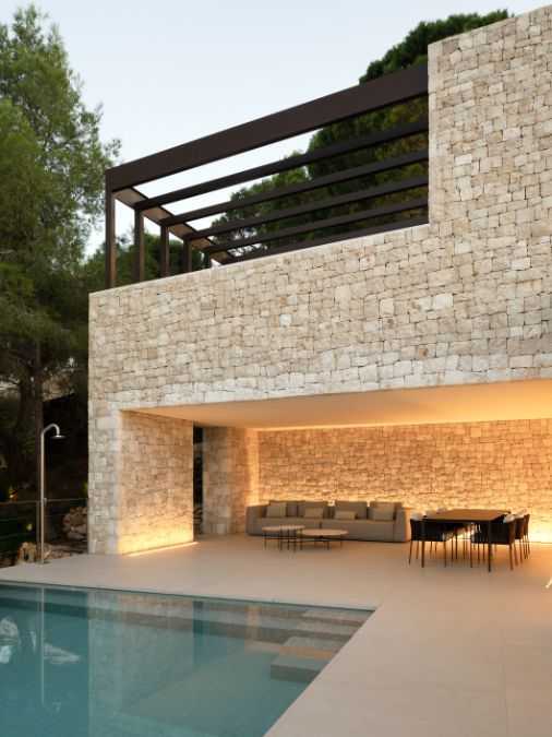 A patio with couch and table and a swimming pool