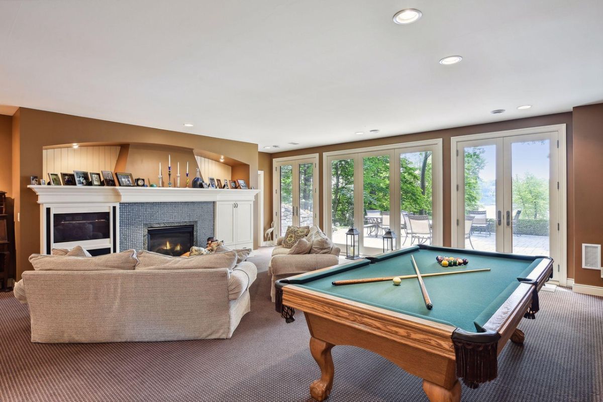 Billiards room with couches and a fireplace.