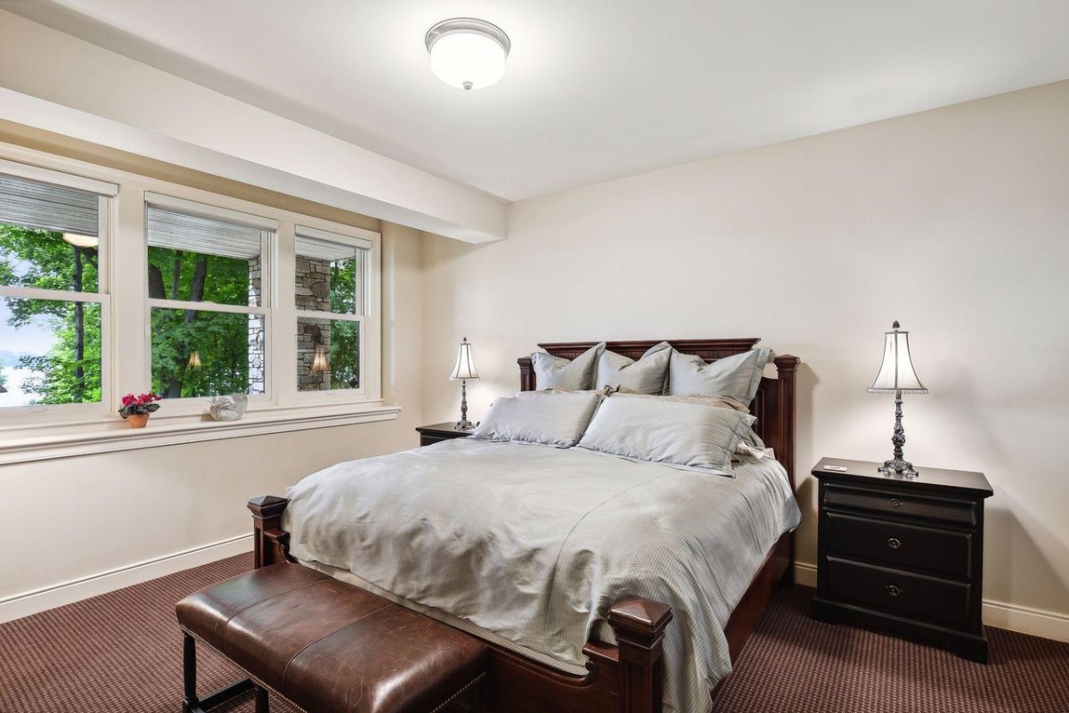 Bedroom with carpet flooring, glass windows, and custom lighting.